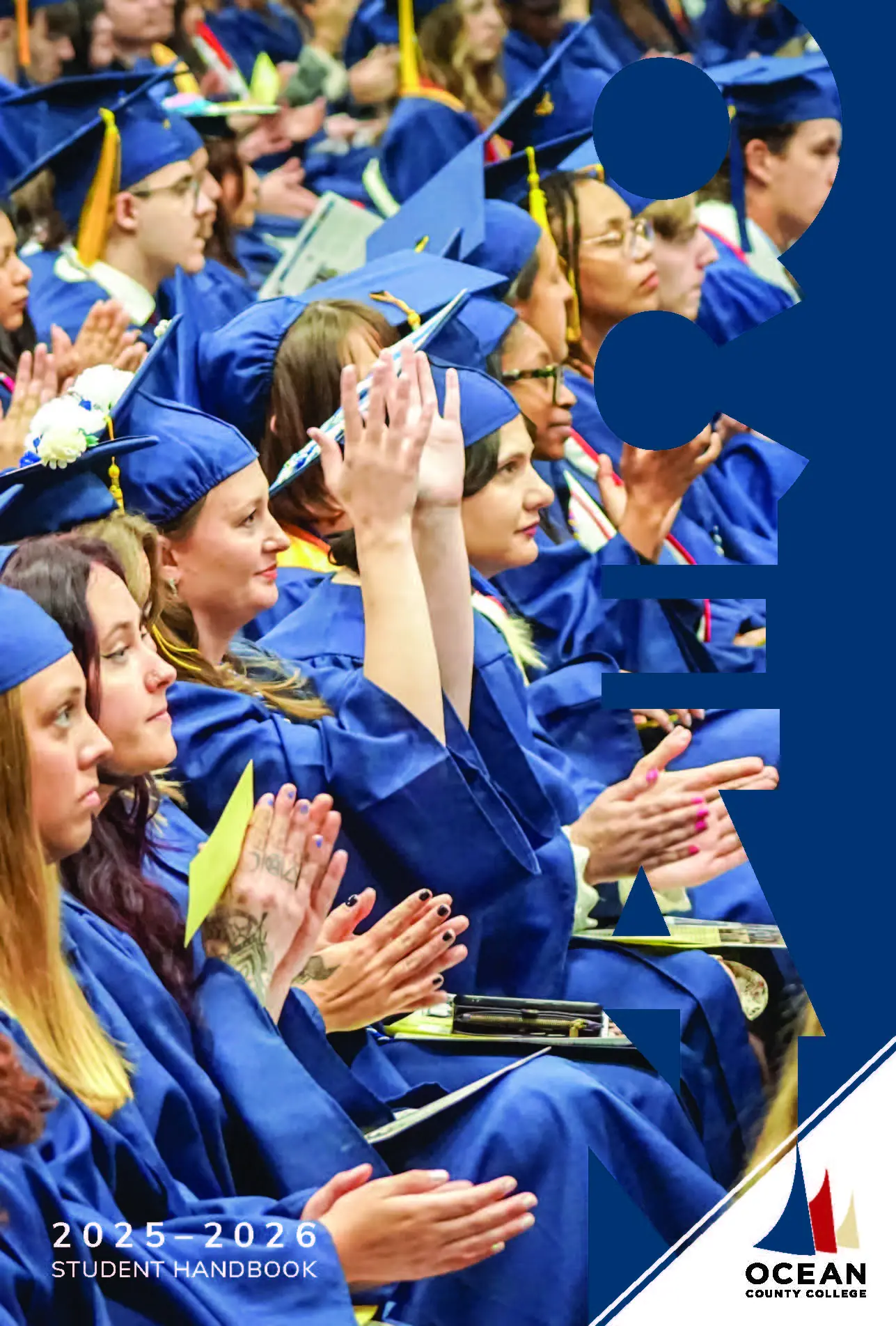 Students sitting at graduation in their caps and gowns.