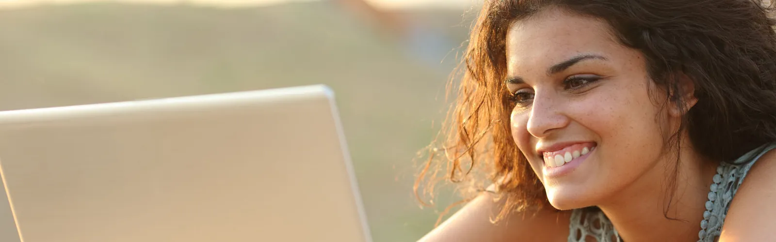 Woman smiling at a computer screen