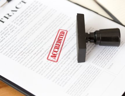 paper with a red stamp of accredited