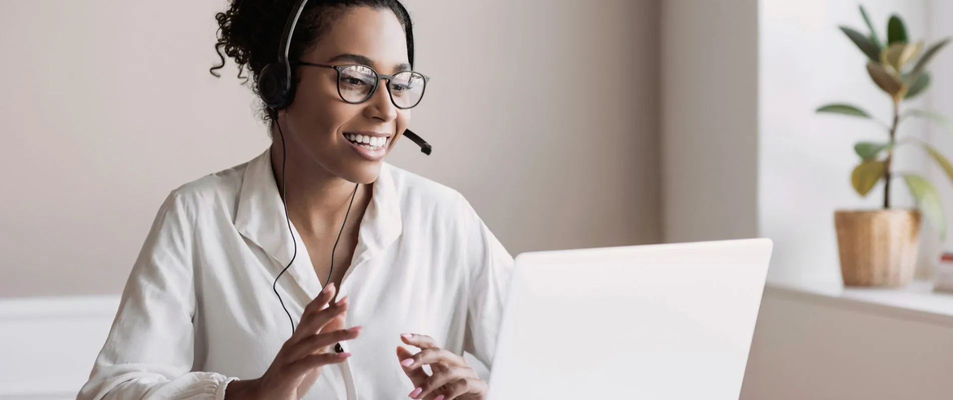 Woman at her laptop talking through a headset