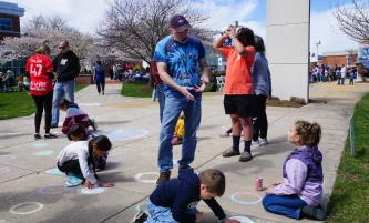 students and kids drawing with chalk